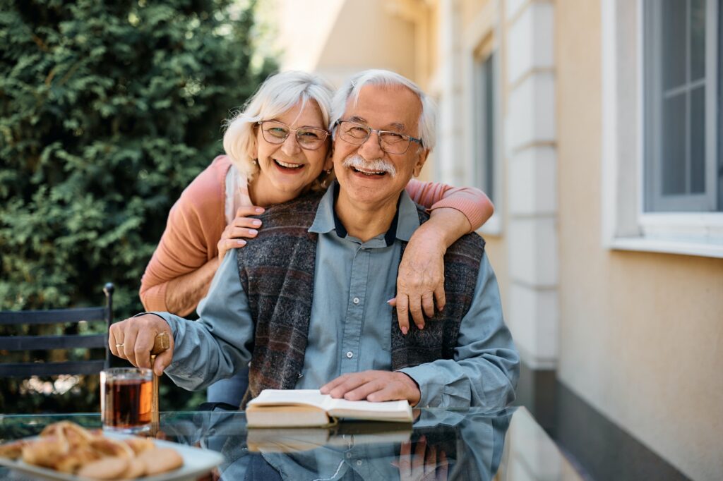 Happy senior couple at independent living community looking at camera.